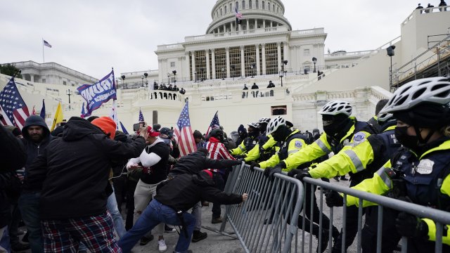Rioters try to break through a police barrier at the Capitol in Washington.