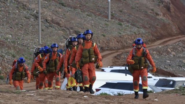 Rescuers walk into the accident site to search for survivors