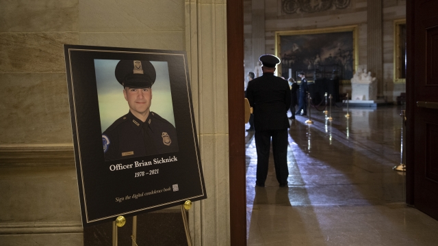 A placard is displayed with an image of the late U.S. Capitol Police officer Brian Sicknick on it.
