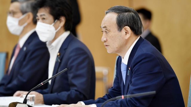 Japanese Prime Minister Yoshihide Suga, right, attends the government task force meeting for the COVID-19 measures