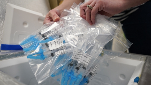 Syringes filled with Johnson & Johnson COVID-19 vaccine are loaded into a cooler