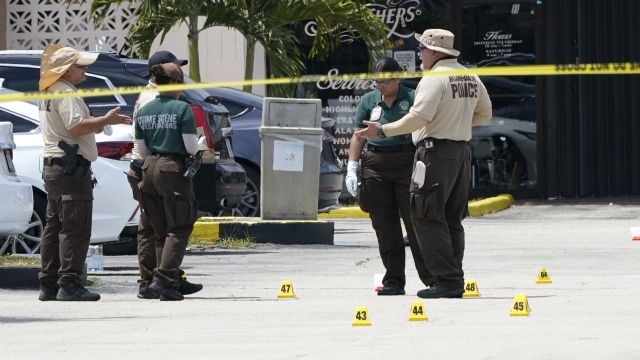 Law enforcement officials work the scene of a shooting outside a banquet hall near Hialeah, Florida