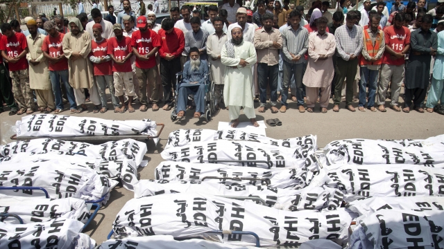 Mourners attend a funeral for unclaimed people who died of extreme weather in Karachi, Pakistan, after a heat wave