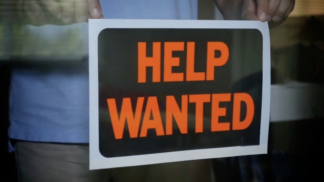 Man hangs a help wanted sign.
