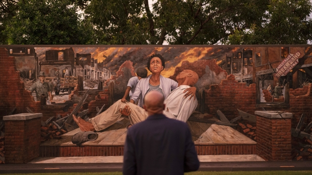 A man looks at a mural depicting the Tulsa Race Massacre in Greenwood neighborhood ahead of the centennial commemoration