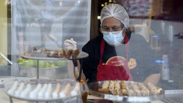 A worker wears a mask while prepares desserts at the Universal City Walk, in Universal City, Calif.