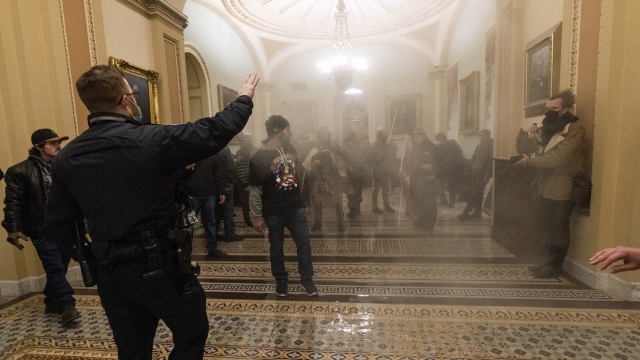 Smoke fills the walkway outside the Senate Chamber as rioters are confronted by U.S. Capitol Police officers.