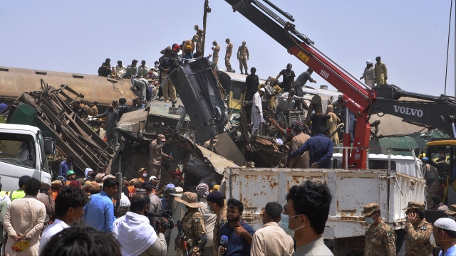 Soldiers use a crane to move wreckage at the site of a train collision in the Ghotki district in southern Pakistan.
