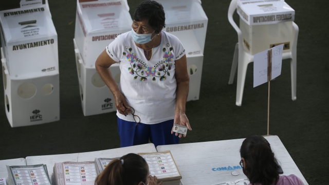 A woman shows her ID before voting in Acapulco, Mexico
