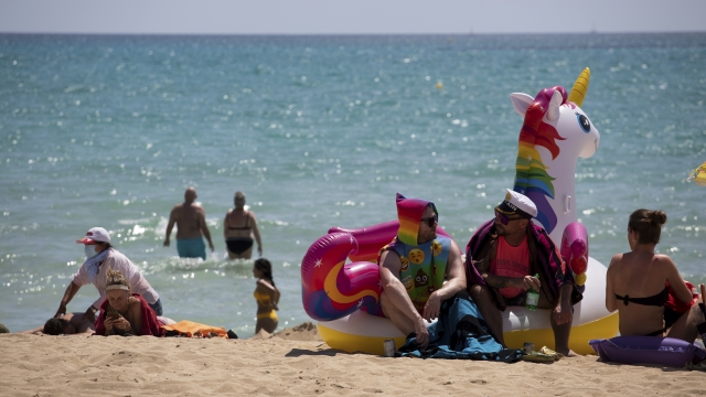 Tourists sunbathe on the beach at the Spanish Balearic Island of Mallorca, Spain, Monday, June 7, 2021.
