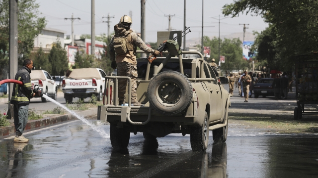 Afghan security personnel leave the scene of a roadside bomb explosion in Kabul, Afghanistan.