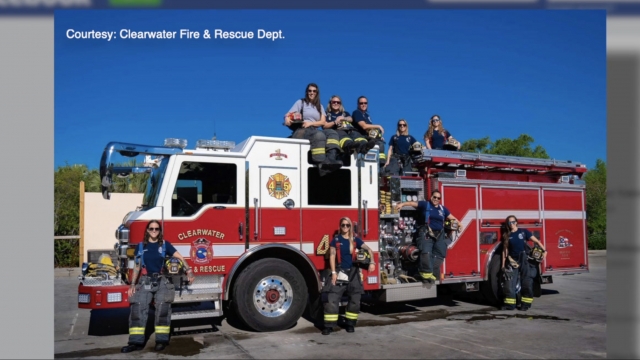 Women pose with a fire truck.