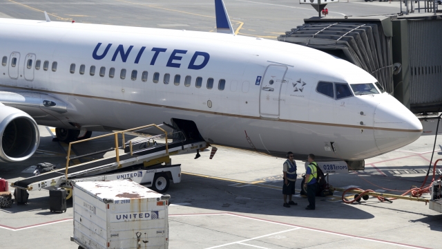 A United Airlines commercial jet at the gate of an airport.