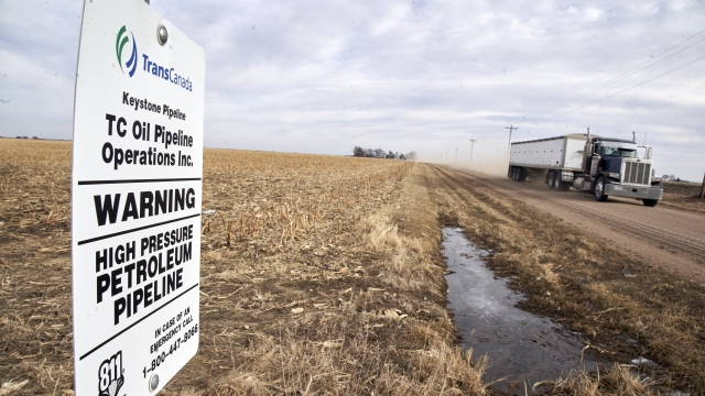 A grain truck drives past a Keystone pipeline pumping station