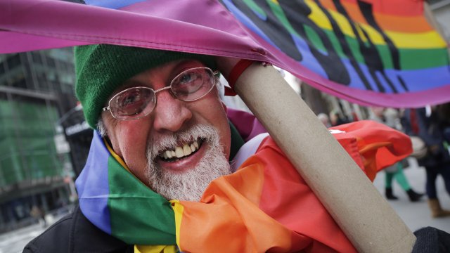 Gilbert Baker, creator of the rainbow pride flag, carries flag