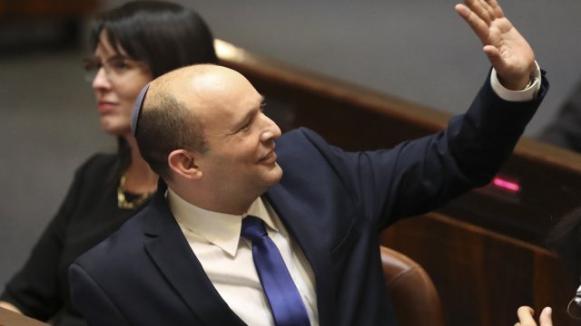 Israel's designated new prime minister Naftali Bennett sends greetings during a Knesset session in Jerusalem June 13, 2021.