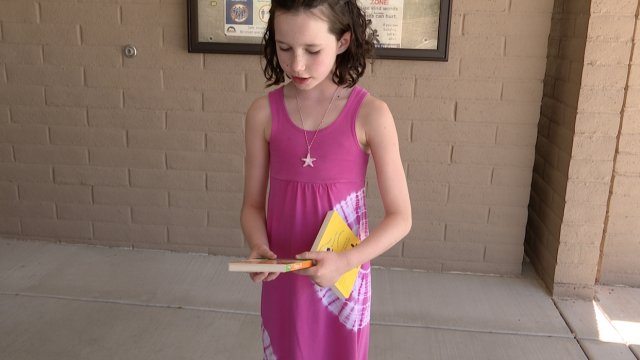 A little girl holds a book.