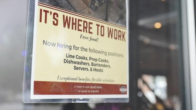 A sign for hiring is dipslayed on a door as patrons walk into Yours Truly restaurant.