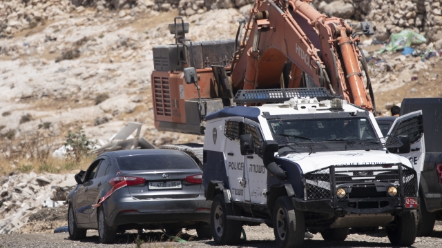 Israeli police tow a car that was said to be used in an attack near Hizmeh Junction in the West Bank, Wednesday.