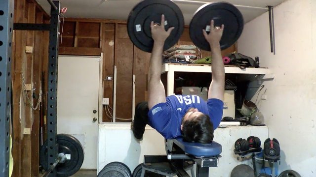 Man lifts weights.