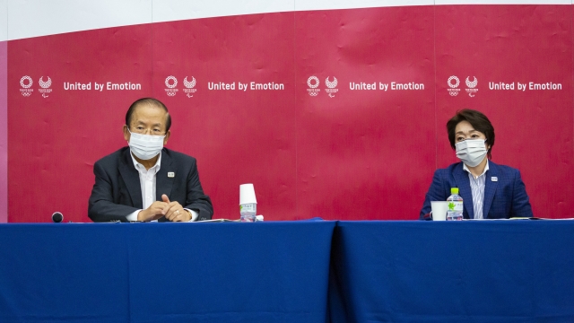 Toshiro Muto and Seiko Hashimoto attend a news conference after receiving a report from a group of of disease experts.