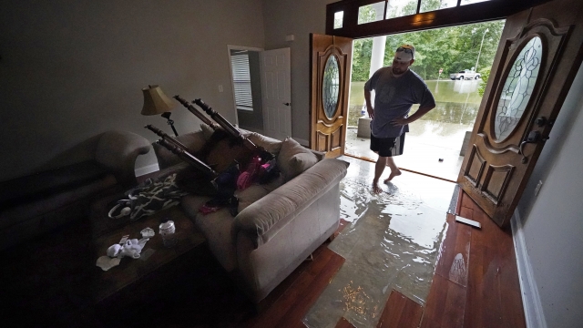 Danny Gonzales walks in his flooded house as water recedes after Tropical Storm Claudette passed through Slidell, La.