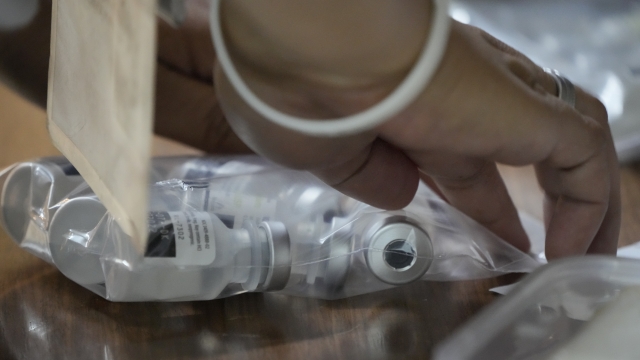 A health worker seals a bag of used Pfizer COVID-19 vials