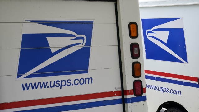 Mail delivery trucks parked outside a post office.