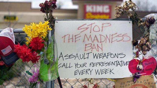 A sign hangs amid the tributes near the King Soopers grocery store in which 10 people died in a mass shooting