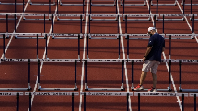 Worker prepares the track for the women's 100-meter hurdles at the U.S. Olympic Track and Field Trials.