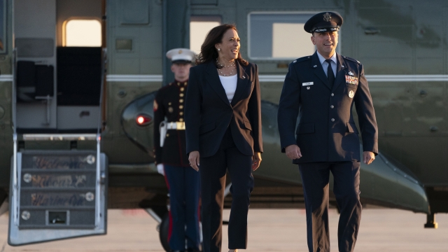 Vice President Kamala Harris, left, walks with Lt. Col Richard "Rick" Hulun, as she arrives to board Air Force Two.