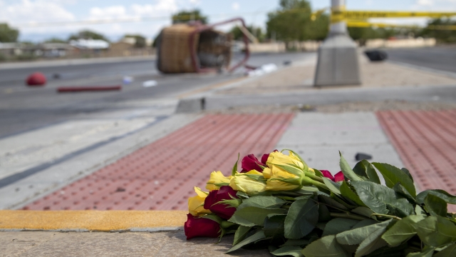 A bouquet of flowers from a mourner is placed near the basket of a hot air balloon that crashed in Albuquerque, New Mexico