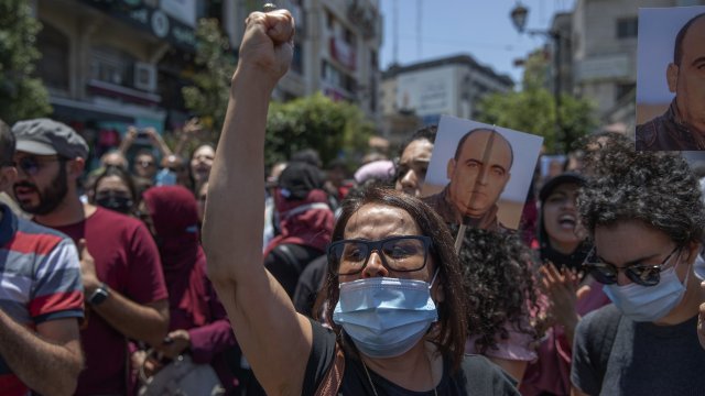 Angry demonstrators carry pictures of Nizar Banat, an outspoken critic of the Palestinian Authority who died in custody.