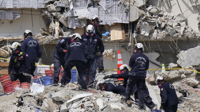 Search and rescue personnel work atop the rubble at the Champlain Towers South condo building.