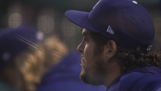 Los Angeles Dodgers starting pitcher Trevor Bauer looks on from the dugout during the fourth inning of a baseball game