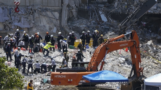 Search and rescue personnel work atop the rubble at the Champlain Towers South condo building