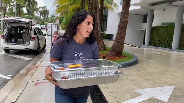 Woman carries trays of food