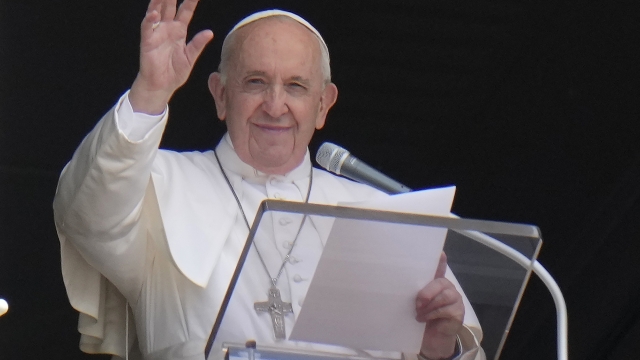 Pope Francis waves to the crowd as he arrives to recite the Angelus noon prayer