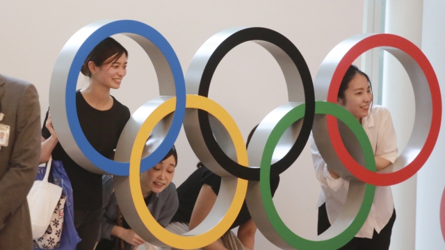 People pose for photo with the Olympics Rings display