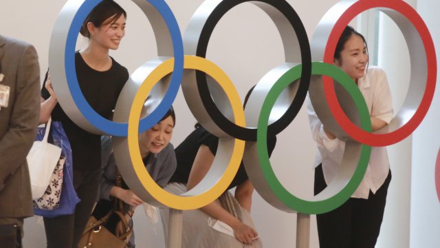People pose with the Olympic Rings