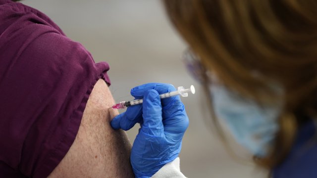 A health care worker receives a second Pfizer-BioNTech COVID-19 vaccine shot
