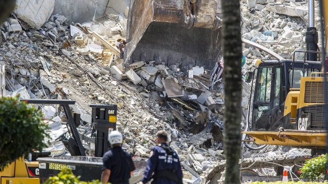 Excavators dig through the rubble of the Champlain Towers South.