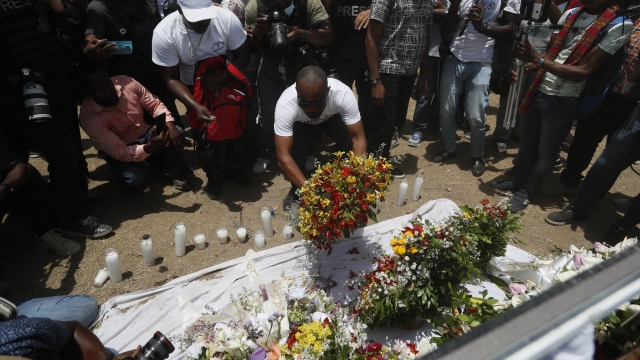 People leave flowers at a memorial for slain President Jovenel Moïse.