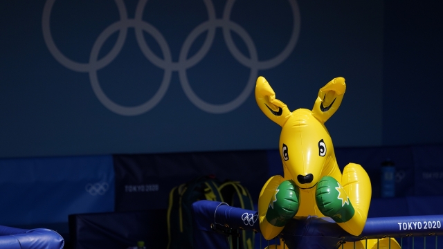 An inflatable boxing kangaroo sits in the dugout as members of the Australian women's softball team