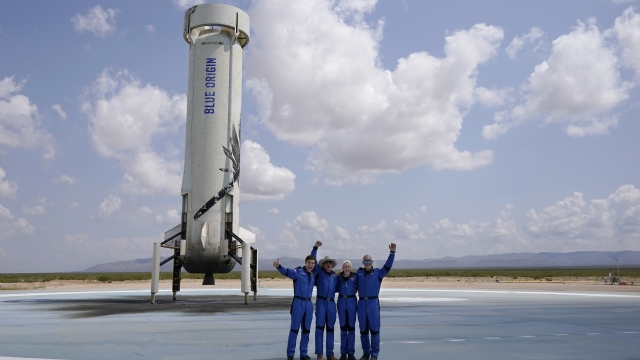 Jeff Bezos and crew with the booster that blasted them into space