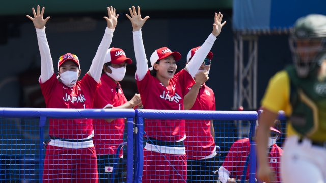 Japanese players celebrate a run scored by Minori Naito.