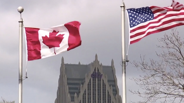 U.S. and Canadian flags fly together.