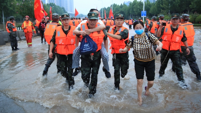 Chinese military personnel evacuate residents from a hospital where 3,000 people were trapped by the flood in Zhengzhou.