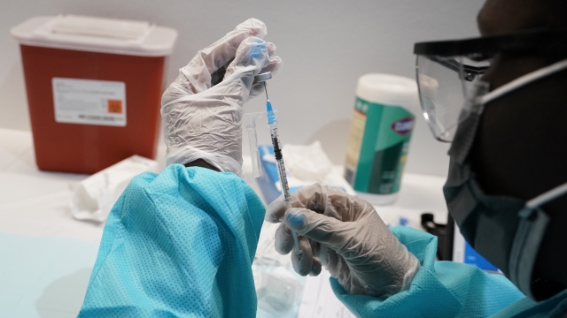 A health care worker fills a syringe with the Pfizer COVID-19 vaccine