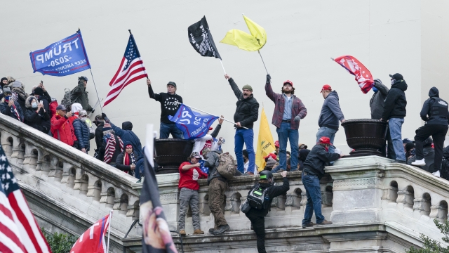 Rioters wave flags on the West Front of the U.S. Capitol in Washington.